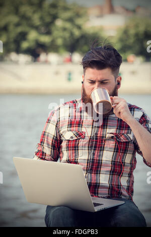 Young hipster man using laptop Stock Photo