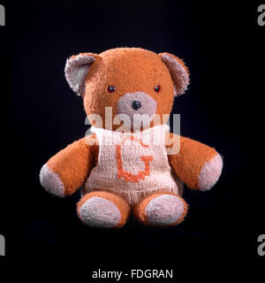 Vintage loved and worn soft toys; monkeys, bears, badgers and rabbits shot individually on a black background in the studio. Stock Photo