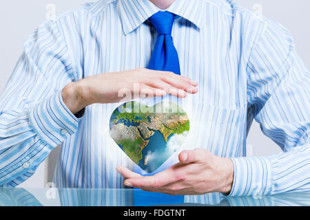 Businessman hands holding heart shaped Earth planet. Elements of this image are furnished by NASA Stock Photo