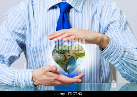 Businessman hands holding heart shaped Earth planet. Elements of this image are furnished by NASA Stock Photo