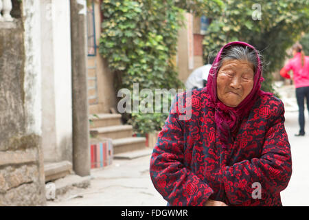 CHINA - JAN 2, A old woman is walking along the street in Xiamen, China on 2 January, 2012. She looks very frustrated. Stock Photo