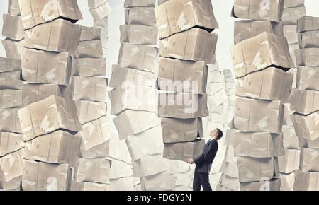 Businessman carrying big stack of carton boxes Stock Photo