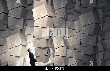 Businessman carrying big stack of carton boxes Stock Photo