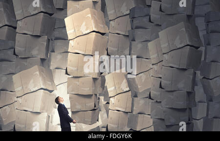 Businessman carrying big stack of carton boxes Stock Photo