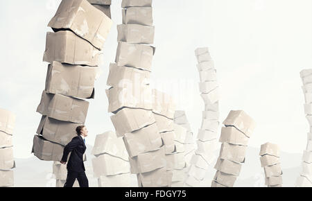 Businessman carrying big stack of carton boxes Stock Photo