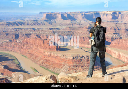 Female tourist taking pictures of a canyon landscape, USA. Stock Photo
