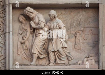 Lot and his daughters flee from Sodom. Marble relief (1800) by Italian sculptor Grazioso Rusca on the main facade of the Milan C Stock Photo