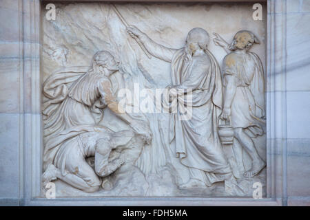 Moses strikes water from the stone. Marble relief on the main facade of the Milan Cathedral (Duomo di Milano) in Milan, Italy. Stock Photo