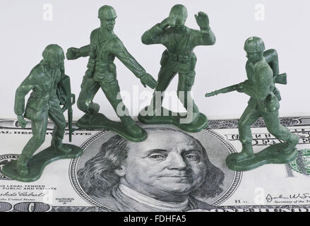 Guarding American money with green toy soldiers. Stock Photo