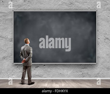 Rear view of businessman looking at chalkboard Stock Photo