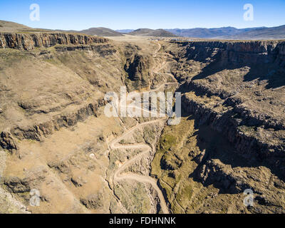 Aerial view of Dirt road winding down the mountainside of Lesotho, Africa Stock Photo