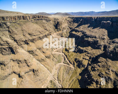 Aerial view of Dirt road winding down the mountainside of Lesotho, Africa Stock Photo