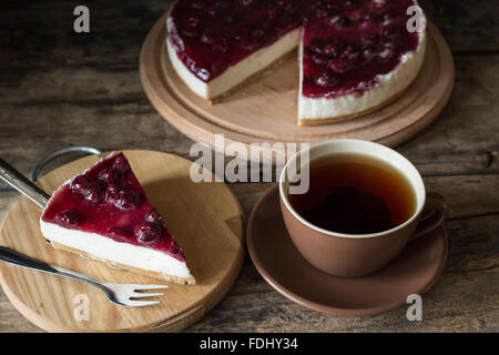 Cup of black tea with slice of cheesecake on wooden background Stock Photo