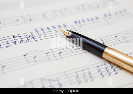 pen and music sheet with handwritten notes Stock Photo