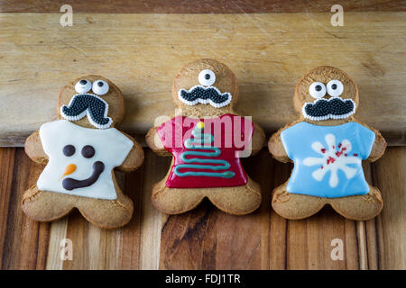 funny gingerbread cookies wearing ugly holiday sweaters and eyes and a mustache Stock Photo