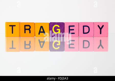 Tragedy - an inscription from children's wooden blocks Stock Photo