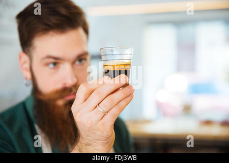 Barista holding glass with coffee in coffee shop. Focus on glass Stock Photo