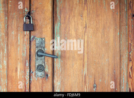 Weathered wooden doors with rusty door handle and padlock Stock Photo