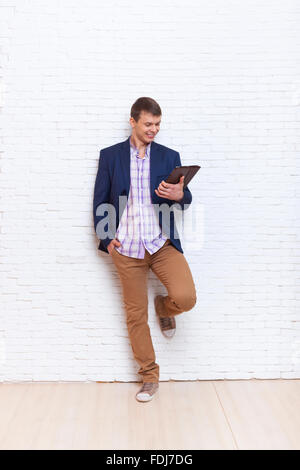 Young Business Man Using Tablet Computer Social Network Communication Stand Over Wall Stock Photo