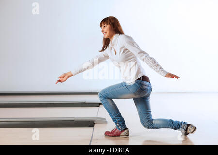 Young pretty woman throwing a bowling ball Stock Photo