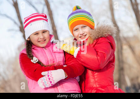 Two cute girls having fun in winter park Stock Photo