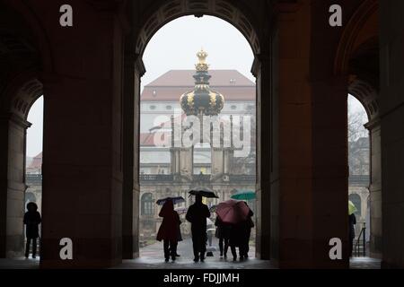 Dresden, Germany. 01st Feb, 2016. People carrying umbrellas stand beneath the Kronentor gate of the Dresden Zwinger palace during rainfall in Dresden, Germany, 01 February 2016. Photo: Sebastian Kahnert/dpa/Alamy Live News Stock Photo