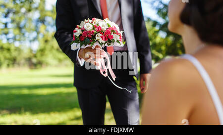 The groom holding wedding bouquet for his bride in the wedding day Stock Photo