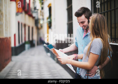 Young couple sightseeing in city with map, Seville, Spain Stock Photo