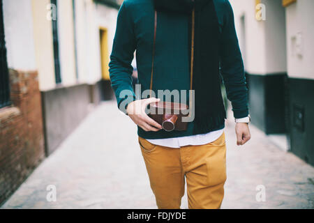 Man walking down street, holding vintage retro  camera, Seville, Spain Stock Photo