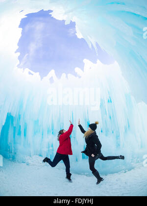 Two friends high five under the Dome Room of the 2015-16 Ice Castle at Hawrelak Park in Edmonton, Alberta, Canada. Stock Photo