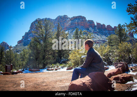 Boy sitting on rock looking at view, Sedona, Arizona, United States Stock Photo