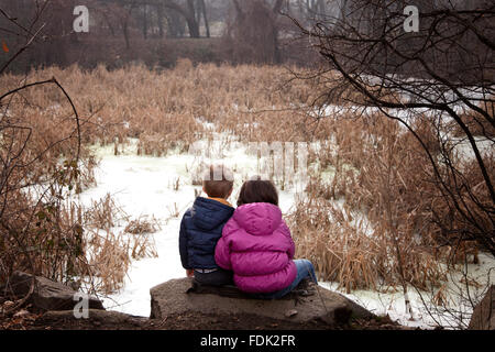 Boy and girl sitting on rock in forest, Sofia, Bulgaria Stock Photo