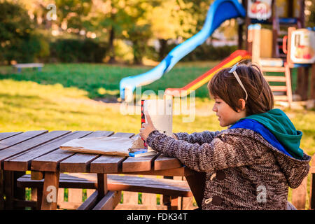 Boy reading a book in a park Stock Photo
