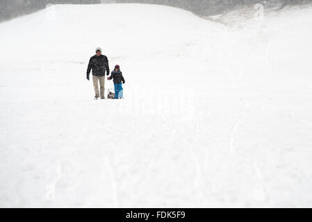 Father and son walking in the snow Stock Photo