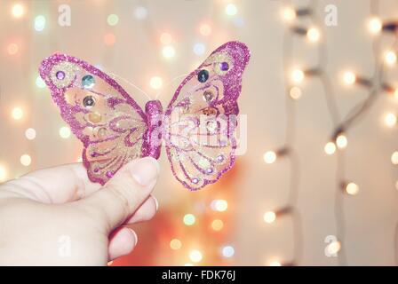 Woman holding purple butterfly decoration Stock Photo