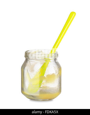 Yellow spoon in empty jar of baby food Stock Photo