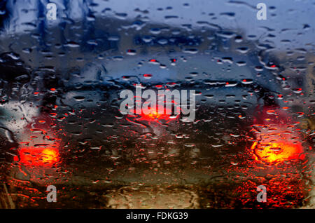 Taillights of a car seen through windscreen on a rainy day Stock Photo
