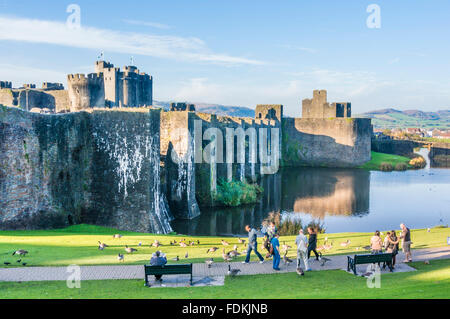 People walking around outside Caerphilly castle a Medieval castle with moat in Caerphilly South Glamorgan South Wales GB UK Europe Stock Photo