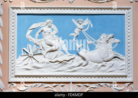 Relief plasterwork in white on Wedgewood blue background on the pink wall of the Staircase at Claydon, Buckinghamshire. Stock Photo