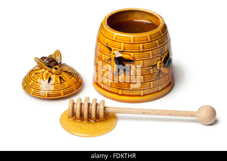 Classic ceramic honey pot with dipper and honeyon white background Stock Photo