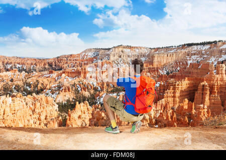 Yong man take picture of Bryce canyon with phone Stock Photo