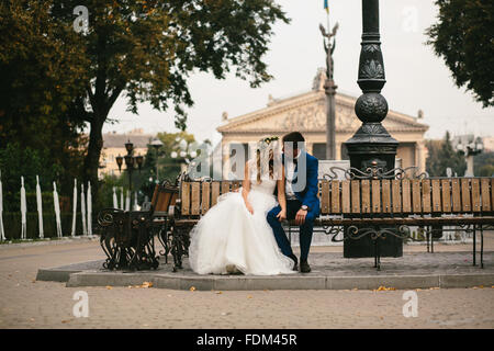 Wedding couple relaxing on a bench Stock Photo