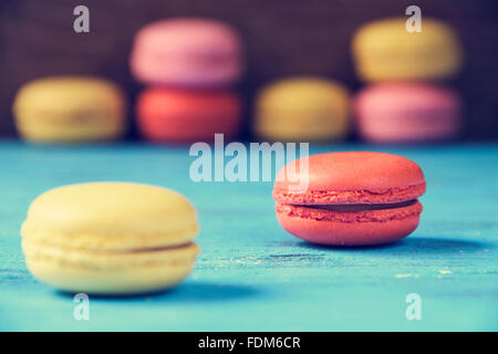 some appetizing macarons with different colors and flavors on a blue rustic wooden surface Stock Photo