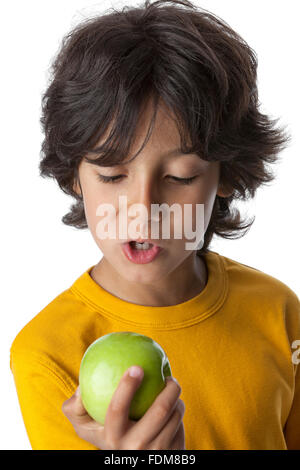 Little boy looking at a green apple on white background, Stock Photo