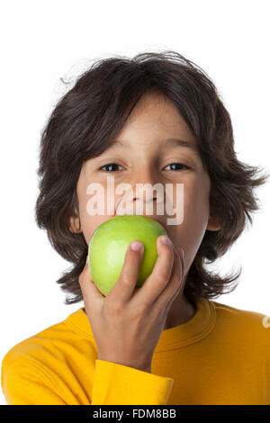Little boy eating a green apple on white background, Stock Photo