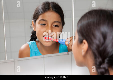 Young teenage girl brushing her teeth in the bathroom Stock Photo