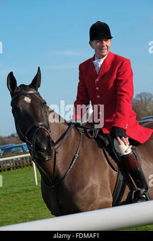 course official in red jacket riding horse at fakenham races, north norfolk, england Stock Photo