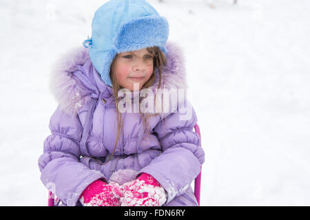 disheveled and happy five year old girl sitting on a sled Stock Photo ...
