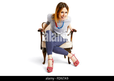 Woman sitting down on a old school chair and laughing Stock Photo