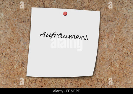 Aufräumen (german clean up) written on a memo pinned on a cork board Stock Photo